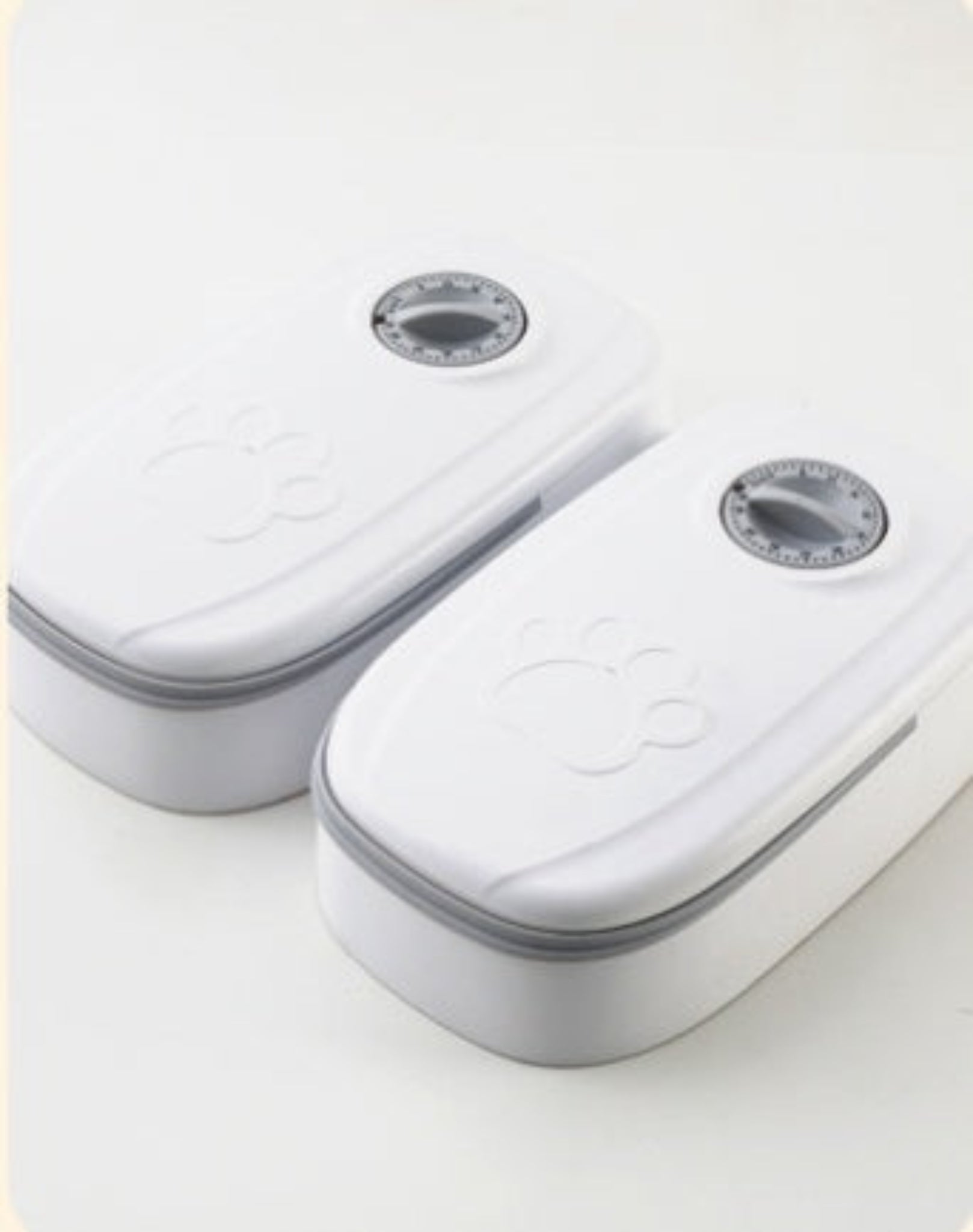 Two white electronic devices with gray accents on a light gray background